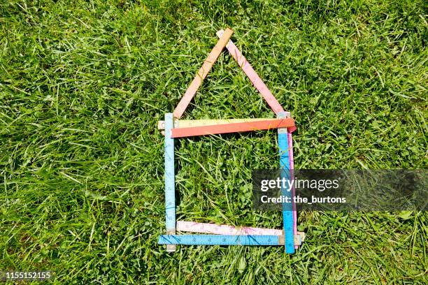 high angle view of a colorful folding ruler in shape of house on a meadow - duimstok stockfoto's en -beelden