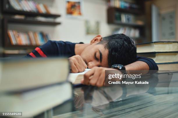 portrait of teenage boy in the library - sleeping table stock pictures, royalty-free photos & images