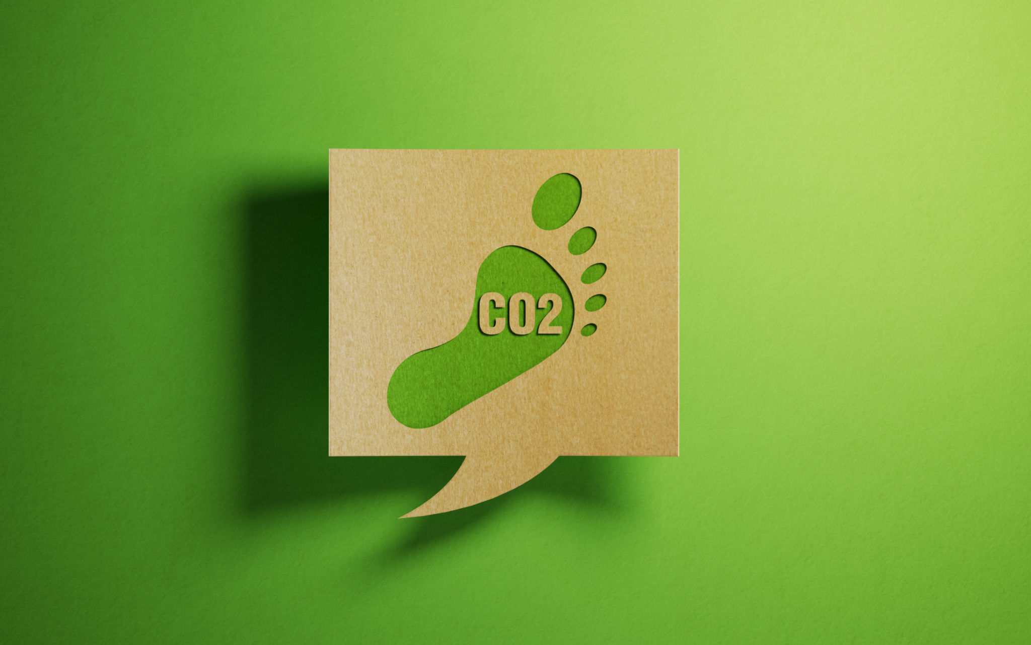 Carbon Footprint Icon on A Chat Bubble Which Is Made of Recycled Paper Over Green Background Carbon Footprint Icon on A Chat Bubble Which Is Made of Recycled Paper Over Green Background