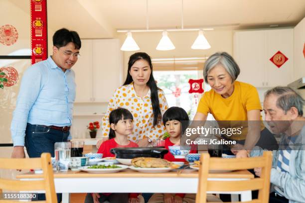 multi-generation family getting ready for chinese new year meal together - lantern festival stock pictures, royalty-free photos & images