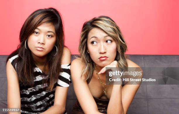 glamorous mixed race women sitting on sofa - asian waiting angry expressions stock pictures, royalty-free photos & images