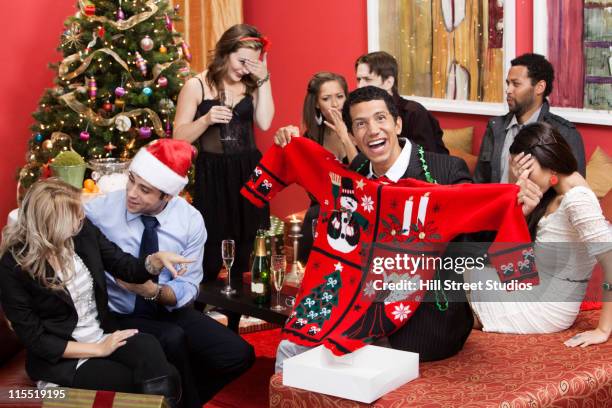 man opening gift at christmas party - sapin de noel humour photos et images de collection