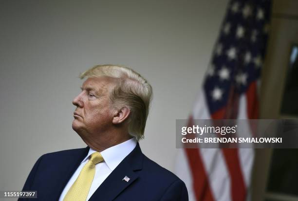 President Donald Trump looks on as the US attorney general delivers remarks on citizenship and the census in the Rose Garden at the White House in...