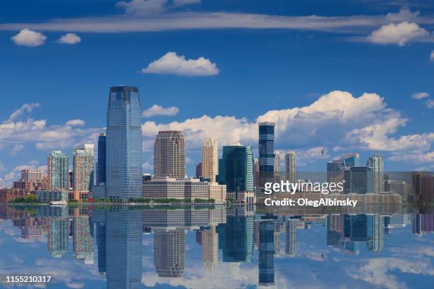 skyline de jersey city avec goldman sachs tower reflété dans l’eau de la rivière hudson, new york, usa. - new jersey photos et images de collection