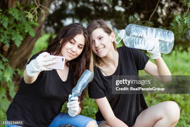 two girls taking a selfie after plogging. - selfie with bottle stock pictures, royalty-free photos & images