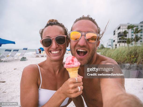 Pareja Feliz En La Playa Comiendo Helado En Verano Y Tomar Foto Selfie Para  Compartir Con Amigos Foto de stock - Getty Images