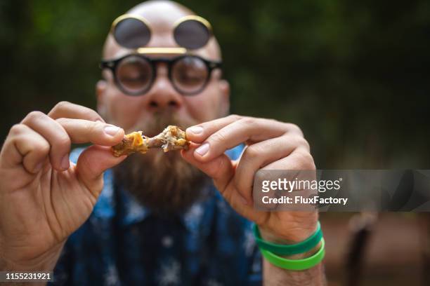 nahaufnahme eines hipster-mannes isst freund hühnchen - chicken wings stock-fotos und bilder