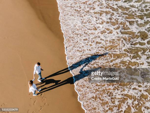 jong paar op het strand gezien vanaf boven - couple dunes stockfoto's en -beelden