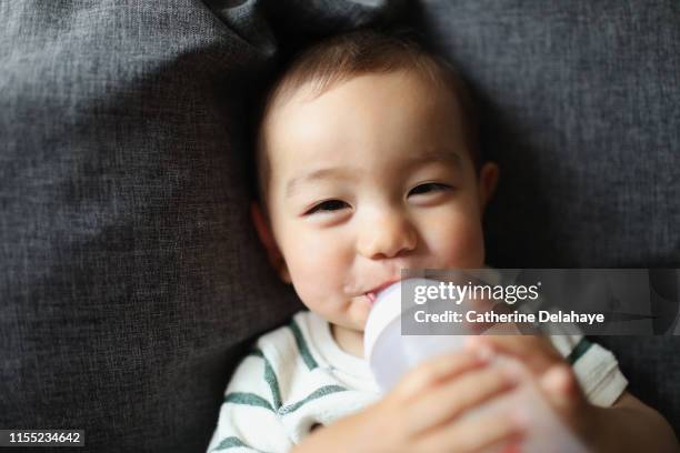 a 1 year old boy at home - 哺乳瓶 ストックフォトと画像