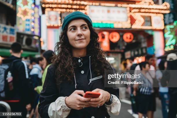 young adult woman using her mobile phone at the night market - taipei market stock pictures, royalty-free photos & images