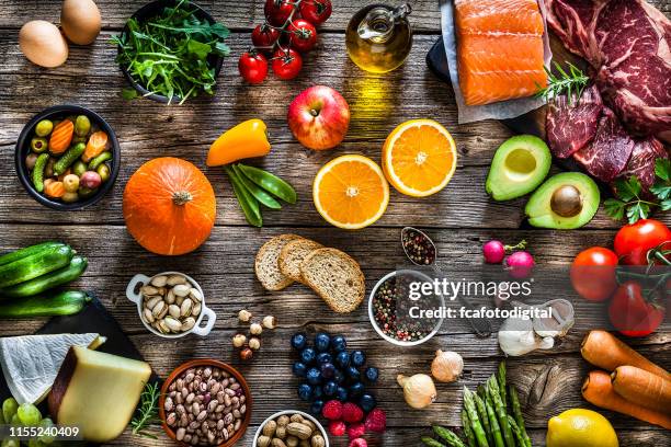 hintergründe: tisch gefüllt mit einer großen vielfalt an lebensmitteln - food wooden table stock-fotos und bilder