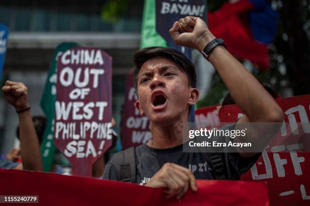 Filipino shouts slogans as he takes part in an anti-China protest outside the Chinese Embassy on July 12, 2019 in Makati, Metro Manila, Philippines....