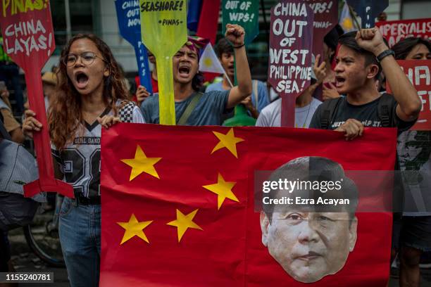 Filipinos hold a mock Chinese flag with a collage of the faces of Philippine President Rodrigo Duterte and Chinese President Xi Jinping during an...