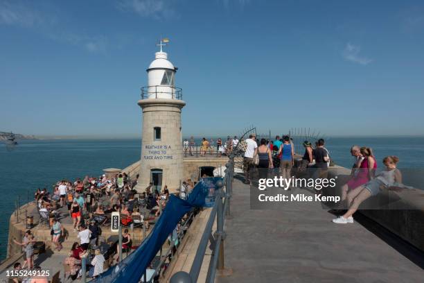 Busy day for people hanging out at the Harbour Arm in Folkestone, England, United Kingdom. Folkestone is a port town on the English Channel, in Kent,...