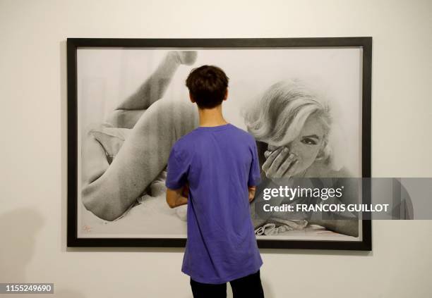 Man looks at a picture taken in 1962 by US photographer Bert Stern displaying US actress Marilyn Monroe, during the exhibition "Divine Marylin" on...