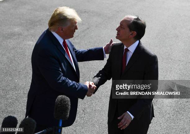 President Donald Trump shakes hands with US Labor Secretary Alexander Acosta during a media address early July 12, 2019 at the White House in...