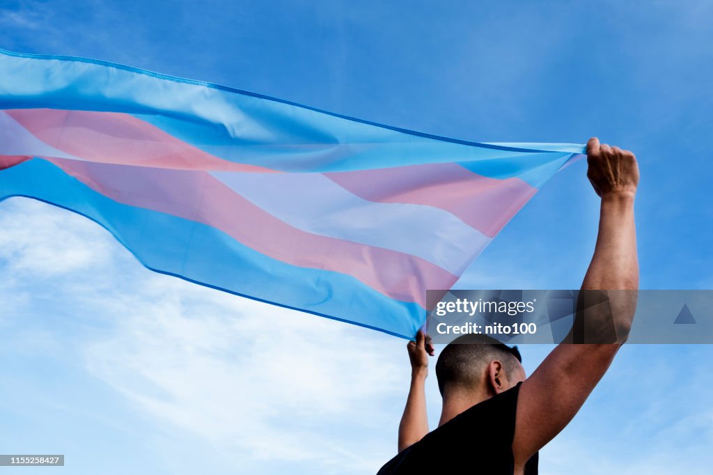 Young person with a transgender pride flag