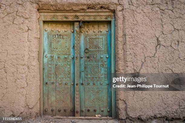 carved entrance door of a rammed earth house, old town of al hamra, sultanate of oman, arabian peninsula - 中東　町 ストックフォトと画像