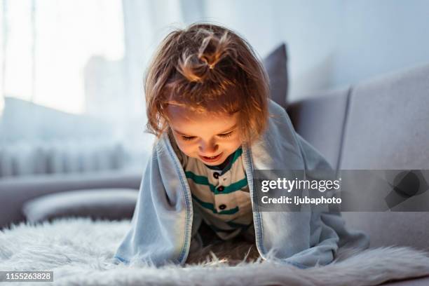 foto van dorable baby boy liggend op de voorkant in het bed en het gebruik van smartphone - under sofa stockfoto's en -beelden