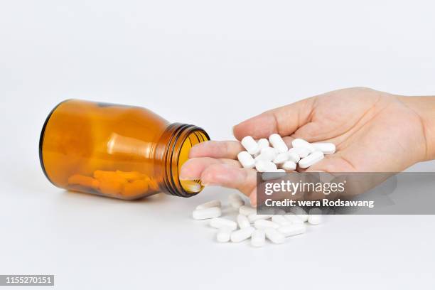 medicine white tablet pills oval paracetamol isolated over white background, hand holding the white tablet pills, white tablet pills in pharmaceutical glass bottles - vitamin sachet stock pictures, royalty-free photos & images