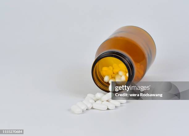 medicine white tablet pills oval paracetamol isolated over white background, white tablet pills in pharmaceutical glass bottles - slaappil stockfoto's en -beelden