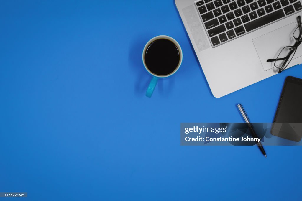 Laptop and Coffee Mud on Blue Work Desk