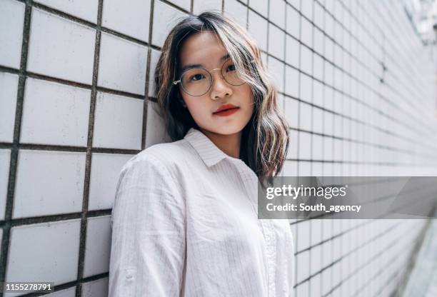 hübsche junge frau mit rotem lippenstift - hipster brille stock-fotos und bilder