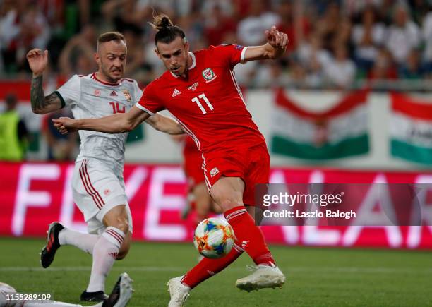 Gareth Bale of Wales misses the ball under pressure from Gergo Lovrencsics of Hungary during the UEFA Euro 2020 Qualifier between Hungary and Wales...
