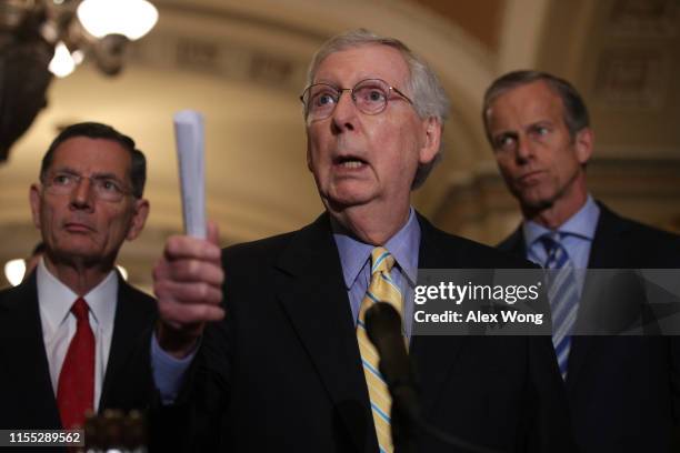 Senate Majority Leader Mitch McConnell speaks as Sen. John Barrasso and Senate Majority Whip John Thune listens during a news briefing after the...