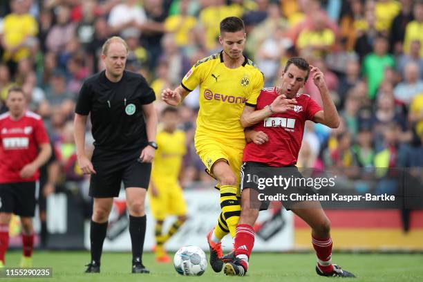 Julian Weigl of Borussia Dortmund challenges Christoph Knoerzer of FC Schweinberg during the pre-season friendly match between FC Schweinberg and...