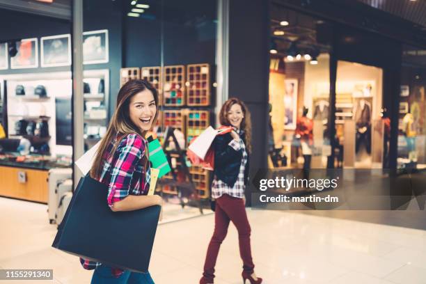 meisjes in het winkelcentrum - black friday shoppers stockfoto's en -beelden