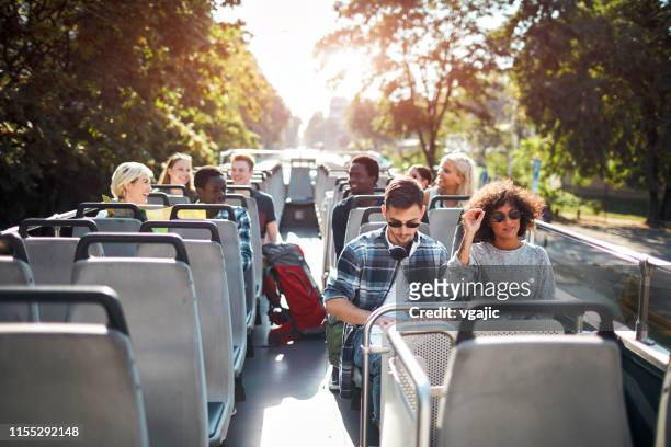 tourists enjoying open top bus tour in the city - open top bus stock pictures, royalty-free photos & images