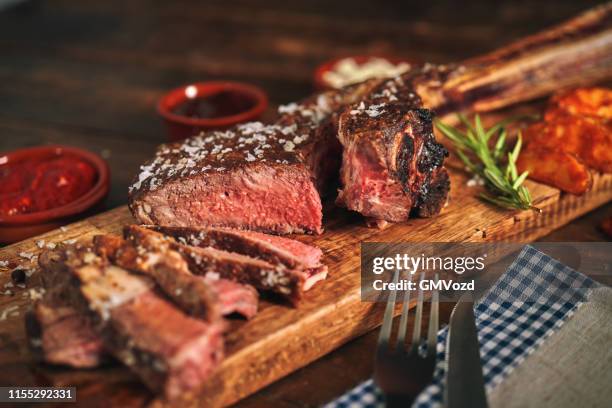 tomahawk steak with country potatoes - grilled steak stock pictures, royalty-free photos & images