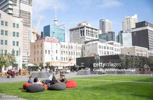 friends sitting in public downtown square - stadsdeel stockfoto's en -beelden