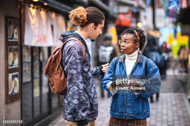 mixed-ethnic vacationers getting smartphone help in tokyo - tourist talking on the phone stock pictures, royalty-free photos & images