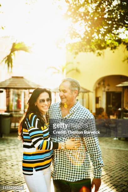 Smiling mature couple embracing while exploring town square