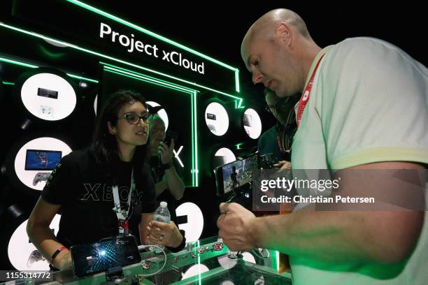 XBox personal demonstrate 'Project xCloud' to game enthusiasts during the E3 Video Game Convention at the Microsoft Theater on June 11, 2019 in Los...