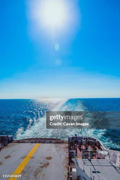 the stern seeing from the deck and waves behid ship in sunny day - flotte stock-fotos und bilder