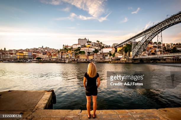 frau mit blick auf den sonnenuntergang über dem douro in porto. - porto portugal stock-fotos und bilder
