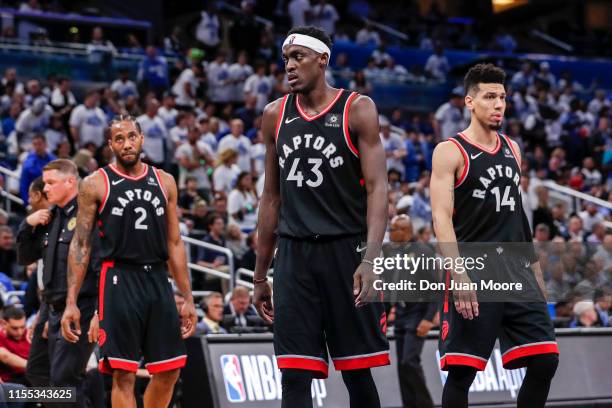 Kawhi Leonard, Pascal Siakam and Danny Green of the Toronto Raptors head back to the court after a time-out against the Orlando Magic during Game...