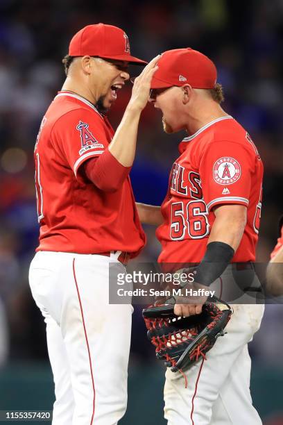 Kole Calhoun and Hansel Robles of the Los Angeles Angels of Anaheim celebrate after defeating the Los Angeles Dodgers 5-3 during a game at Angel...