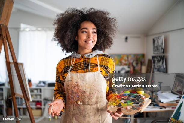 glimlachende jonge afro vrouw holding kleurenpalet en penseel - kunstenaar stockfoto's en -beelden