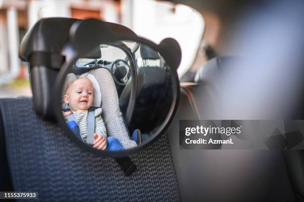 baby boy in einem auto sicherheitssitz - car mirror stock-fotos und bilder