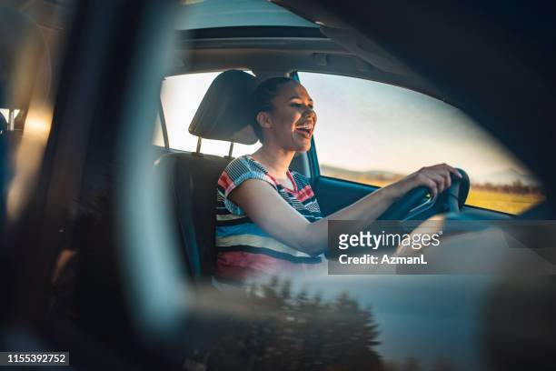 young woman driving car on a sunny day - person singing stock pictures, royalty-free photos & images