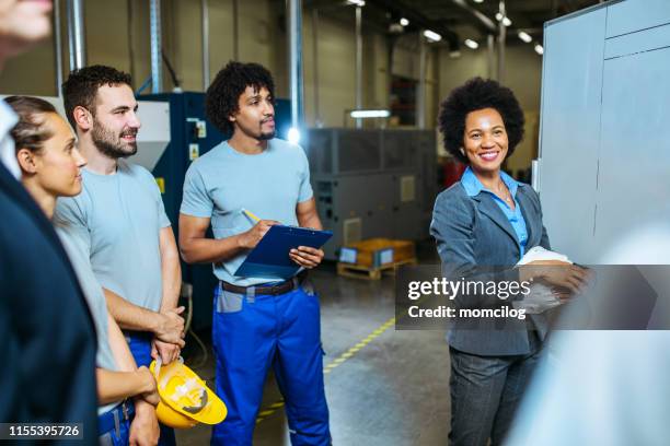 manager und arbeitnehmer, die sich innerhalb der fabrik treffen - african american mechanic stock-fotos und bilder