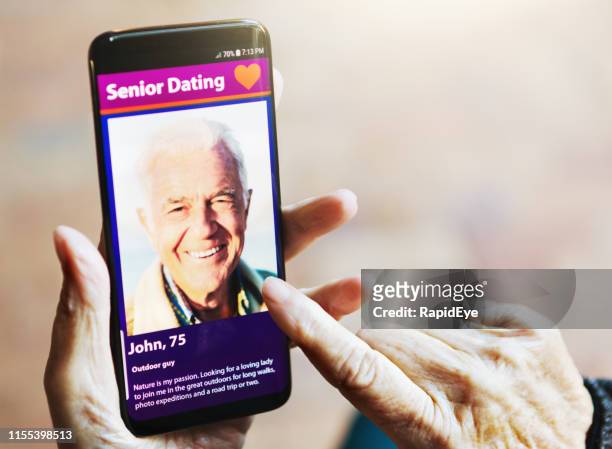 wrinkled female hand swipes dating app image of handsome man - senior romance stock pictures, royalty-free photos & images