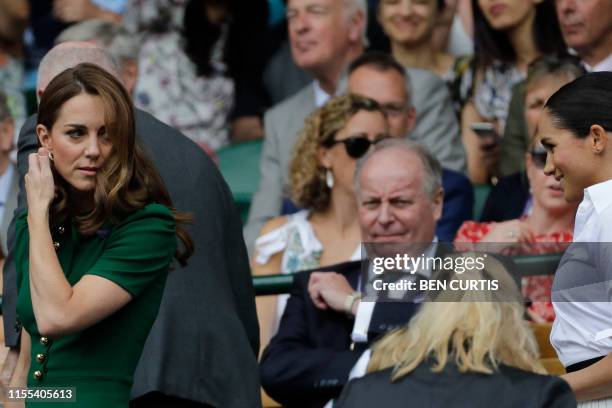 Britain's Catherine , Duchess of Cambridge and Britain's Meghan, Duchess of Sussex, arrive to watch Romania's Simona Halep playing US player Serena...