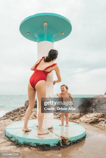 boy using shower at the beach - retro swimwear stock pictures, royalty-free photos & images