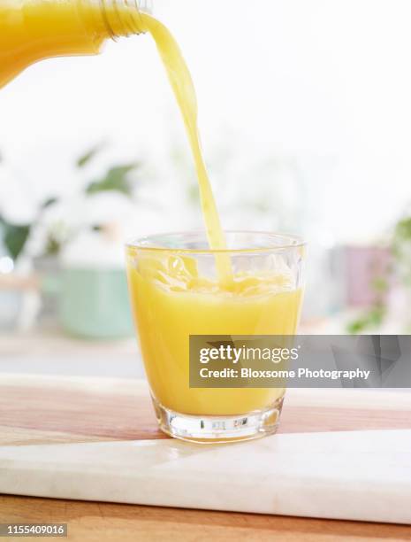 pouring orange juice - jus stockfoto's en -beelden