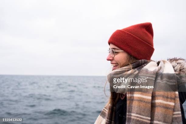 profile of stylish woman laughing in front of lake in winter - duluth minnesota stock pictures, royalty-free photos & images